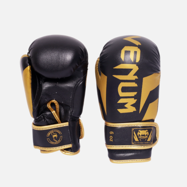 Gants de boxe Venum noir et or avec rembourrage haute densité et fermeture velcro. Protection, confort et design premium pour entraînement et combat.